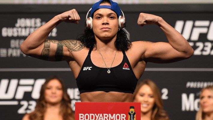 Amanda Nunes poses on the scale as she weighs in