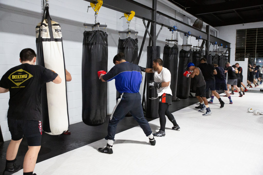 boxers hitting the bag at a beginners boxing martial arts classes