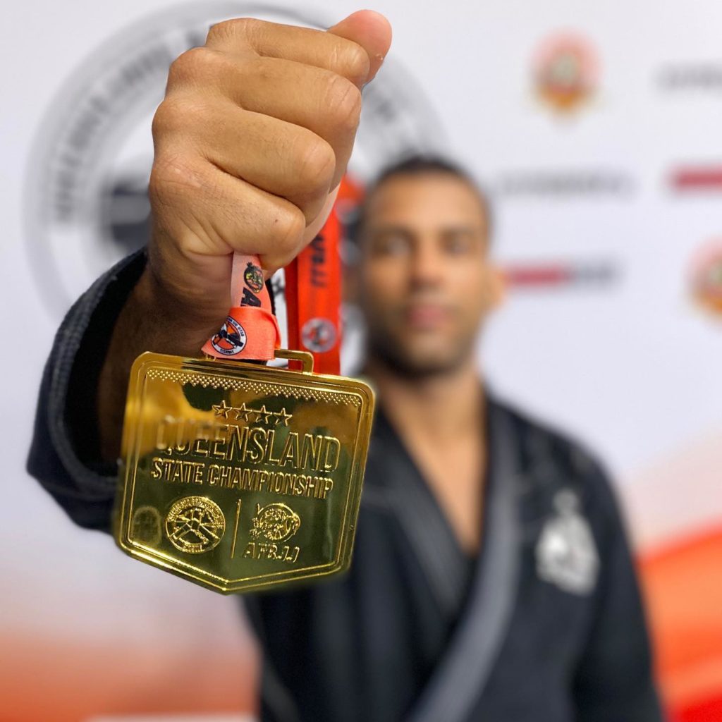 Icaro holds up his gold medal from the Queensland State Championships